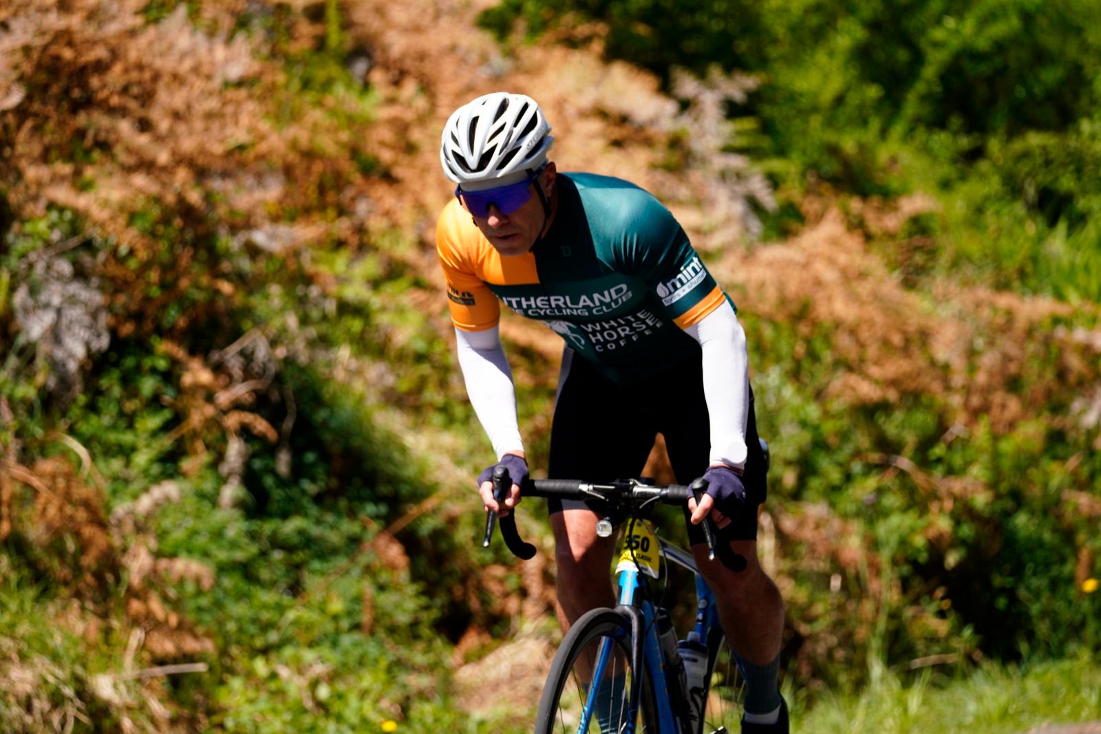 Eduardo Rodrigues racing a road bike on a sunny climb.